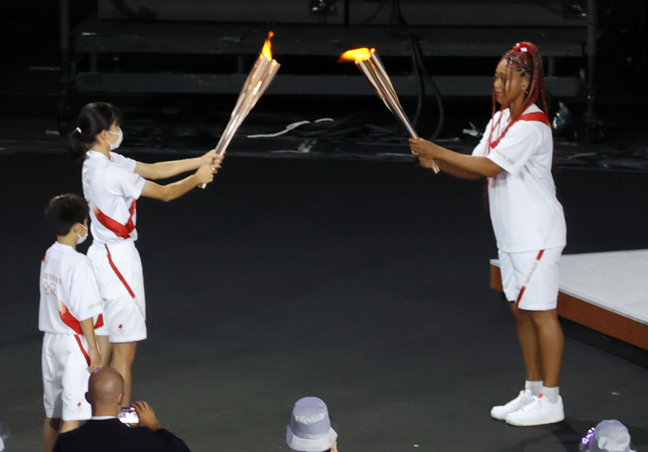 23일 일본 도쿄 신주쿠 국립경기장에서 열린 2020 도쿄올림픽 개막식에서 오사카 나오미가 성화를 받고 있다. [연합]