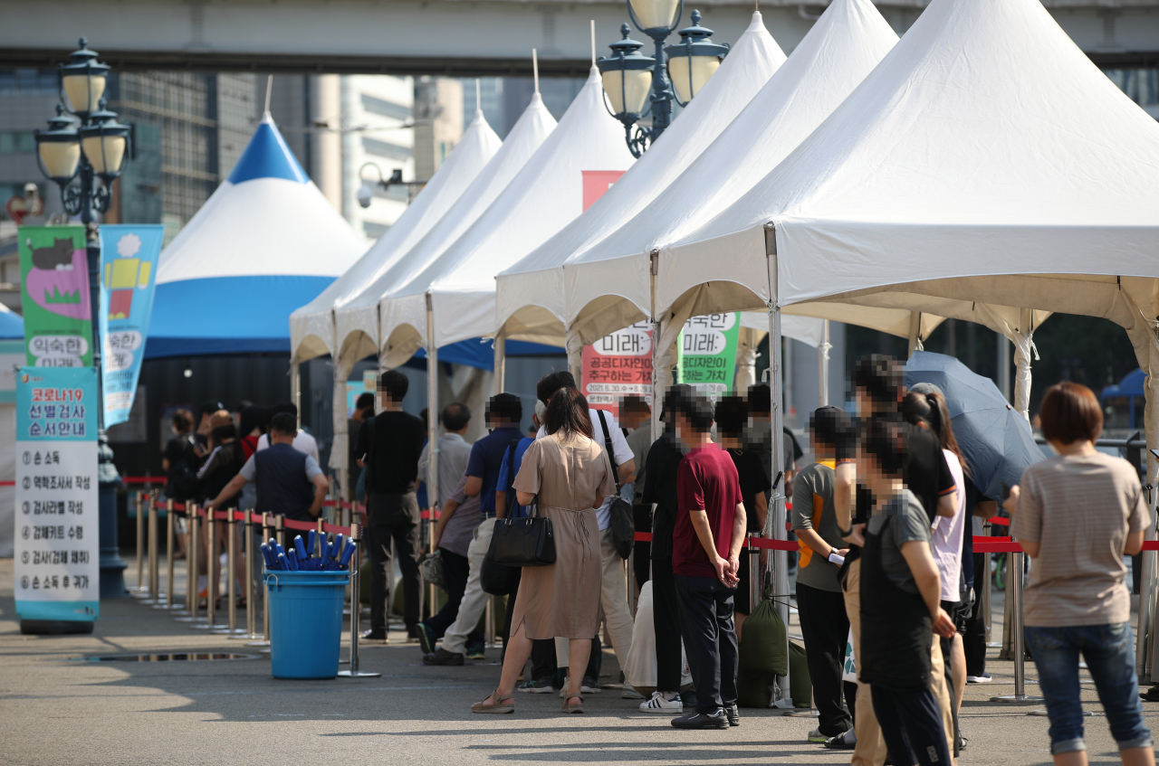 지난 23일 오전 서울역 광장에 마련된 중구임시선별검사소에서 시민들이 검사를 받기 위해 줄을 서 있다. [연합]