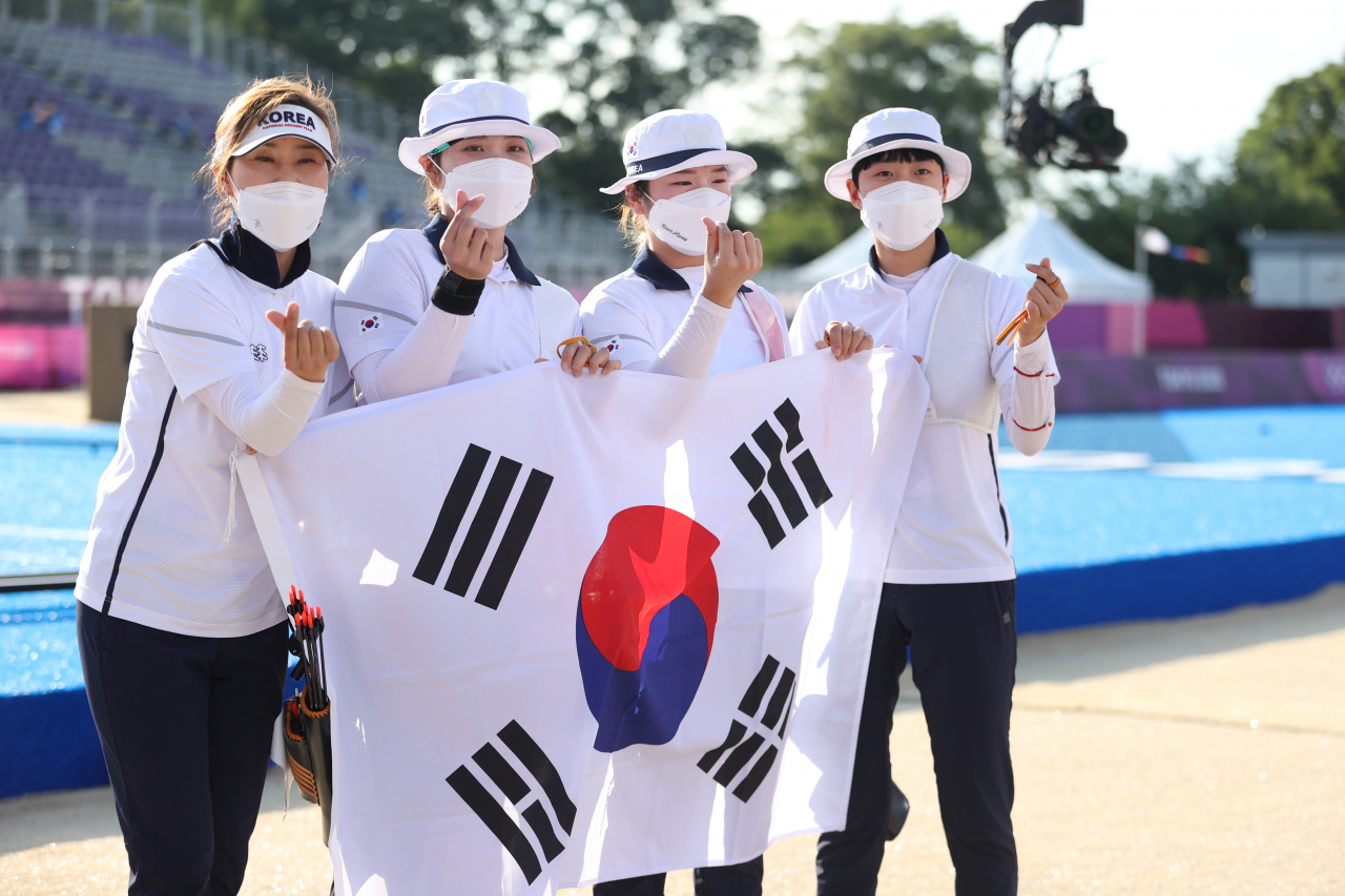 '이번에도 금메달입니다.' 25일 일본 유메노시마 공원 양궁장에서 열린 도쿄올림픽 여자 양궁 단체전 경기에서 금메달을 획득한 여자 양궁 대표팀이 태극기를 들고 포즈를 취하고 있다. 연합뉴스
