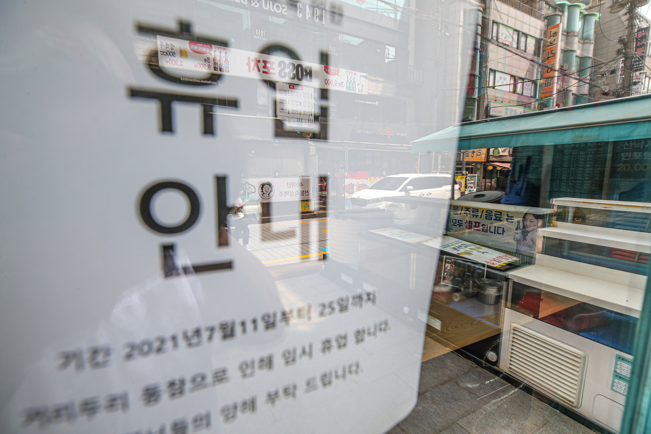 코로나19 델타 변이가 무서운 속도로 확산하고 있는 가운데 팬데믹 이후 최초로 사회적 거리두기 4단계 적용된 첫날인 지난 12일 오후 서울 서대문구 신촌의 한 횟집에 휴업 안내문이 붙어 있다. [연합]