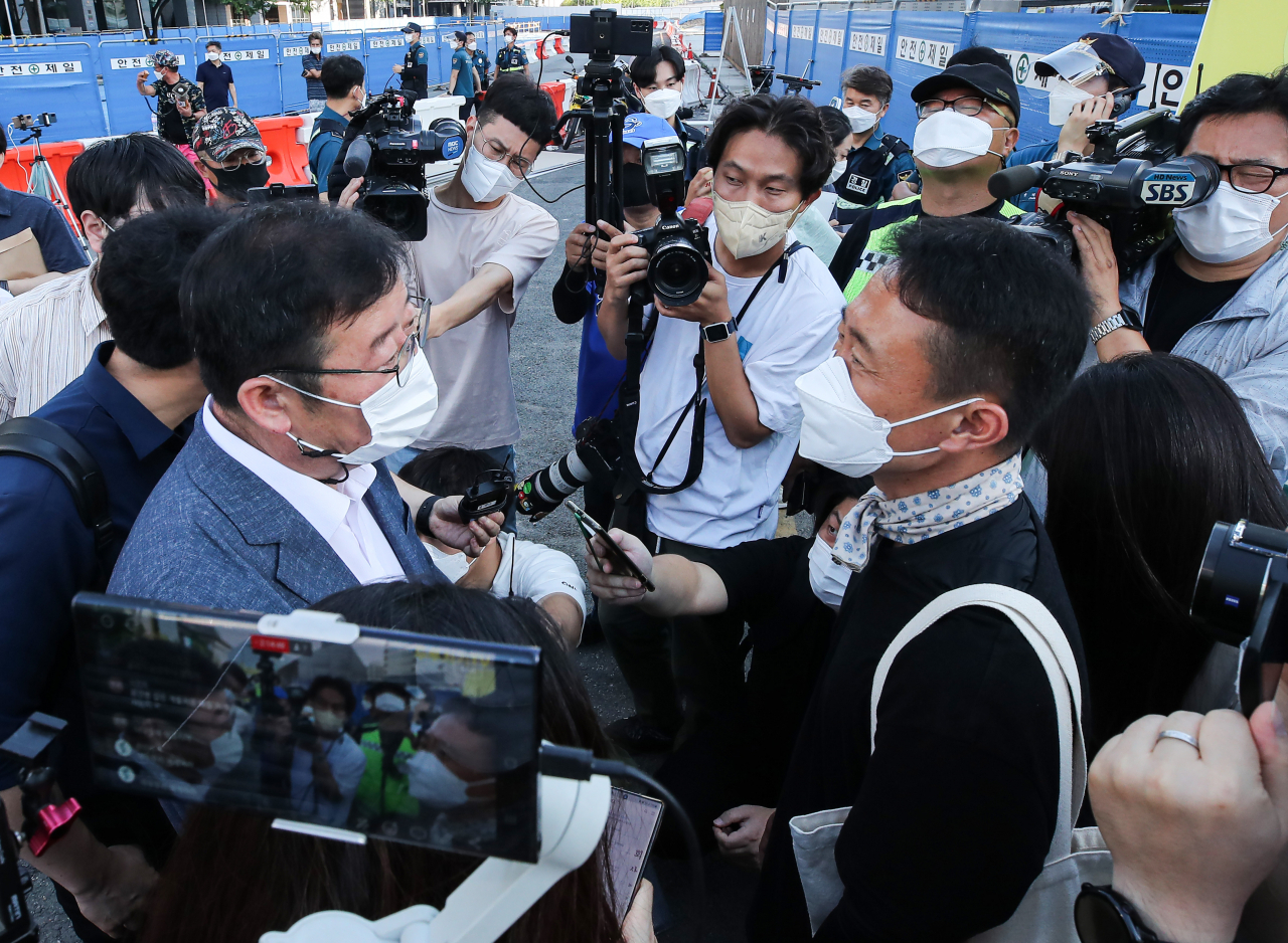 서울시가 광화문 광장 재구조화 공사를 위해 광장에 있는 '세월호 기억공간' 철거를 예고한 26일 오전, 세월호 기억공간 입구에서 서울시 김혁 총무과장(왼쪽)이 김선우 4·16연대 사무처장에게 철거와 관련한 입장을 전달하고 있다. [연합]