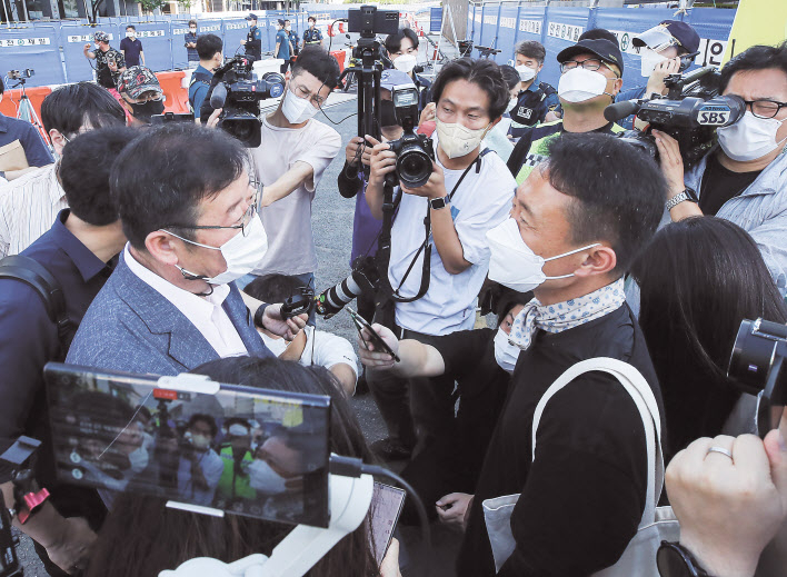 서울시가 광화문광장 재구조화 공사를 위해 광장에 있는 ‘세월호 기억공간’ 철거를 예고한 26일 오전, 세월호 기억공간 입구에서 서울시 김혁(왼쪽) 총무과장이 김선우 4·16연대 사무처장에게 철거와 관련한 입장을 전달하고 있다. [연합]