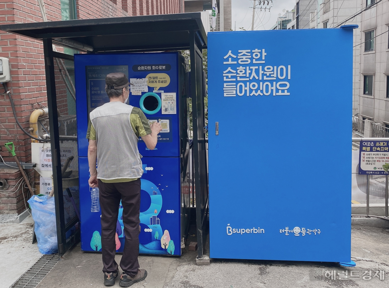 낙성대동 주민센터 앞에서 한 주민이 스마트 수거함에 빈 병을 버리고 있다. [관악구 제공]