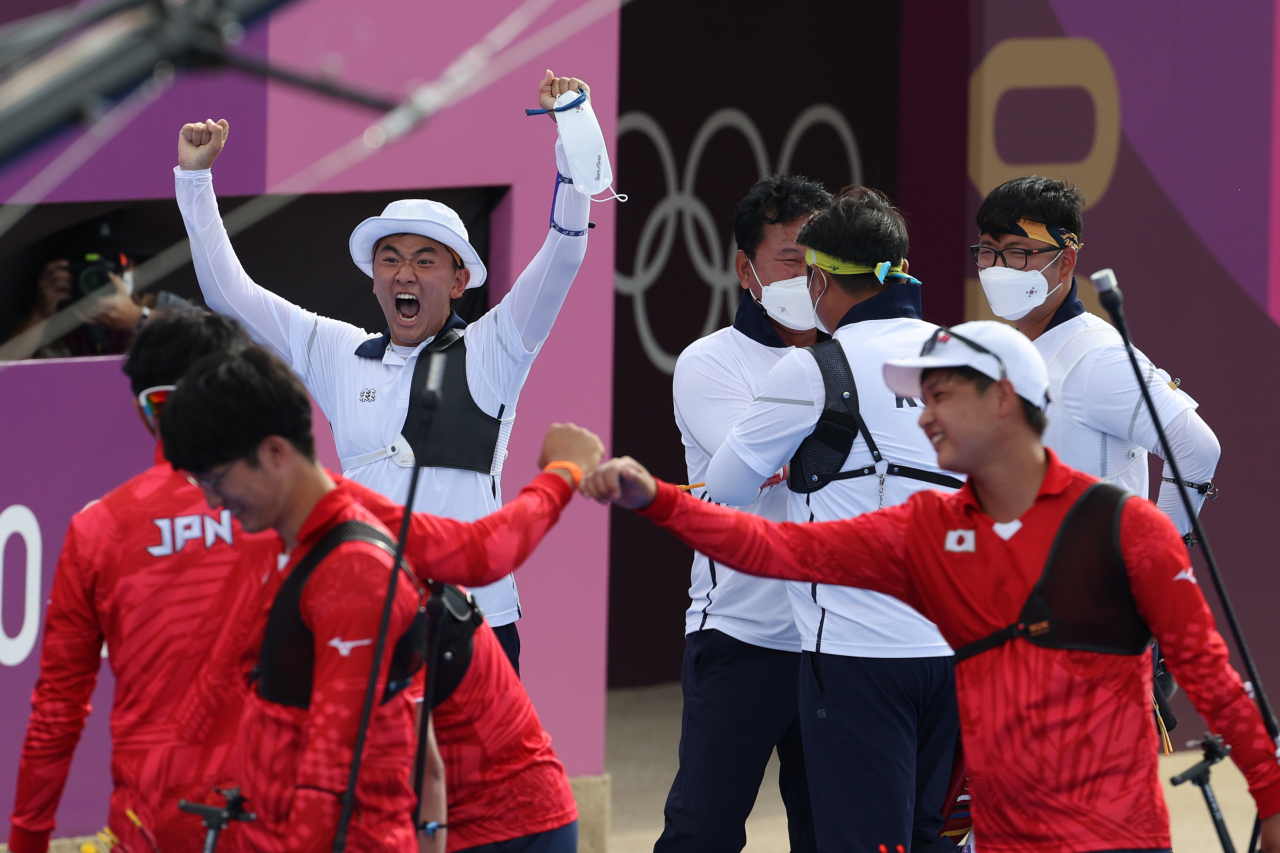 26일 일본 도쿄 유메노시마 공원 양궁장에서 열린 양궁 남자단체전 준결승전 일본과의 경기에서 한국의 김우진, 김제덕, 오진혁이 명승부를 펼친 뒤 결승진출의 기쁨을 나누고 있다. 김제덕은 일본전 슛오프에서 승부를 가르는 10점 화살을 쏘았다. 연합뉴스