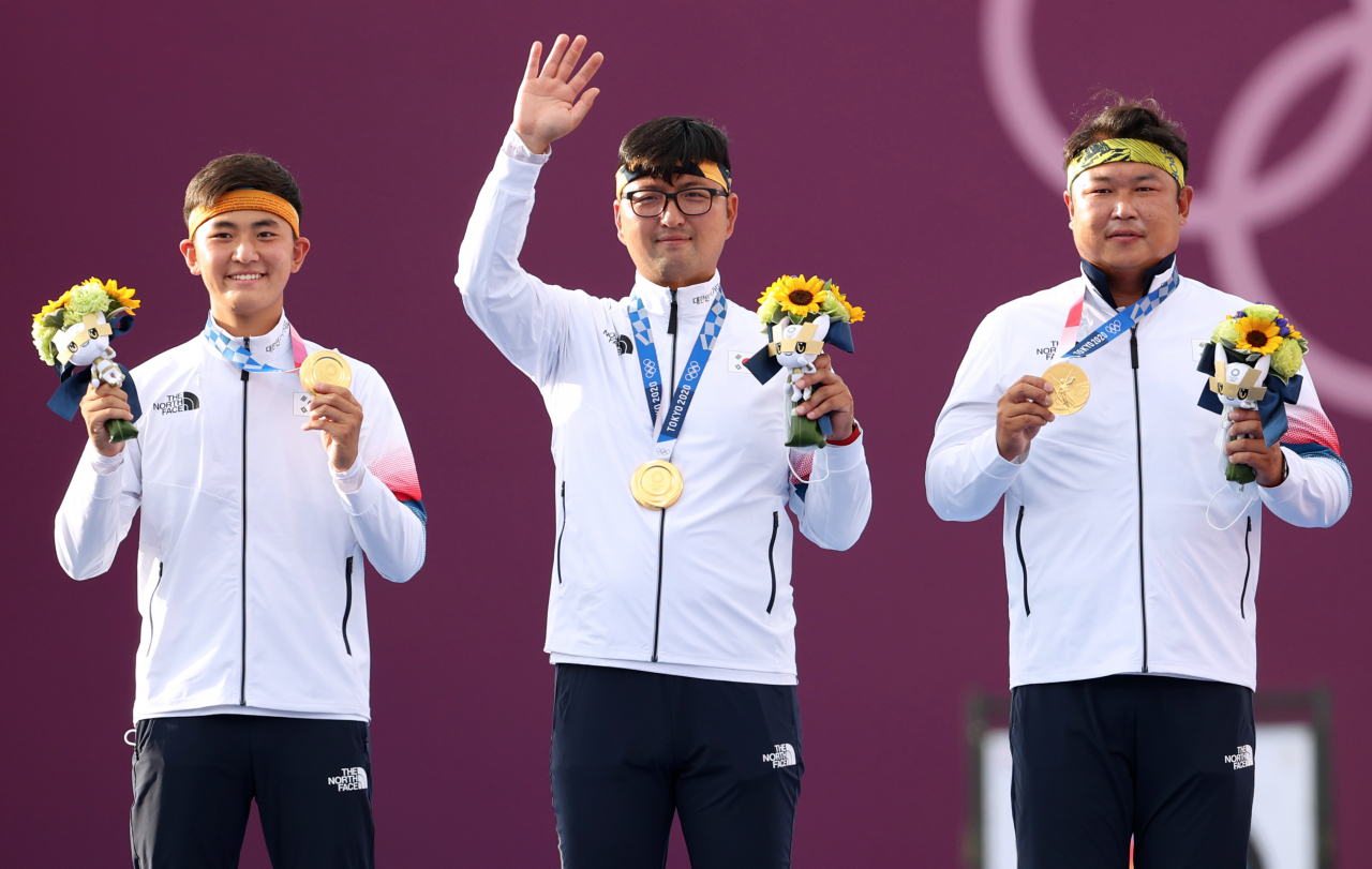 김제덕(왼쪽부터), 김우진, 오진혁이 일본 유메노시마 공원 양궁장 시상대에서 금메달을 보이고 있다. [연합]