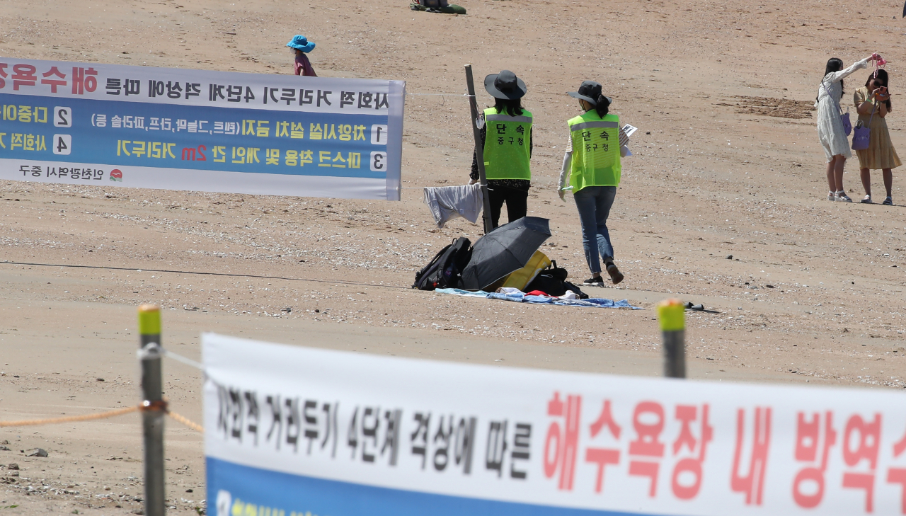 신종 코로나바이러스 감염증(코로나19) 확진자의 급증으로 사회적 거리두기 4단계가 내려진 26일 오후 인천 중구 을왕리 해수욕장에서 방역 담당 공무원들이 백사장을 순찰하고 있다. 연합뉴스