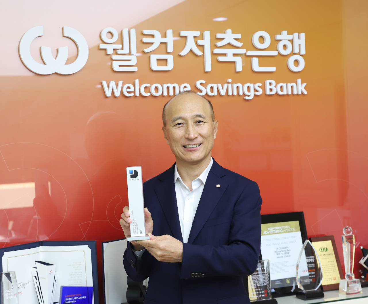 김대웅 웰컴저축은행 대표이사가 2021 대한민국 디지털애드어워즈 금상 트로피를 들고 기념 사진을 촬영하고 있다.
