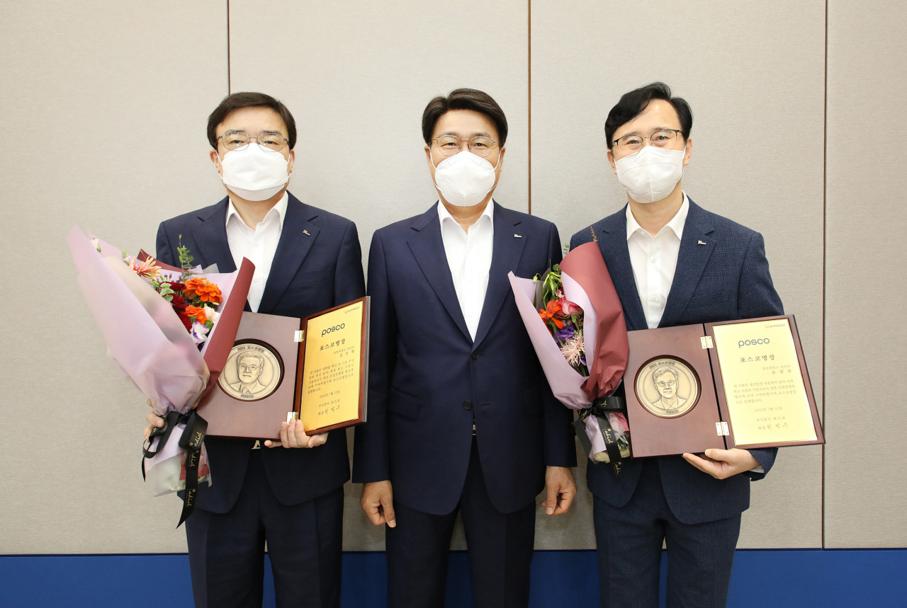 포스코그룹 최정우 회장(가운데)이 최근 열린 그룹운영회의에서 2021년 ‘포스코 명장’으로 선정된 포항제철소 제선부 김수학 차장(왼쪽)과 광양제철소 냉연부 손광호 과장(오른쪽)에게 각각 포스코 명장 임명패를 수여하고 기념촬영을 하고 있다. [포스코 제공]
