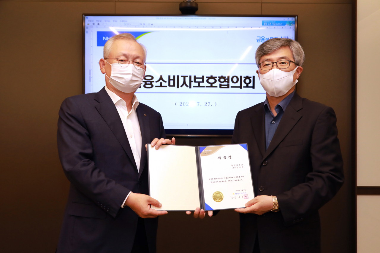 NH투자증권은 27일 여의도 본사에서 ‘2021년 제4차 금융소비자보호협의회’를 개최했다. NH투자증권 정영채 사장(왼쪽)과 이날 협의회 전문위원으로 위촉된 김병연 건국대 교수(오른쪽)가 함께 기념촬영을 하고 있다.[출처: NH투자증권]