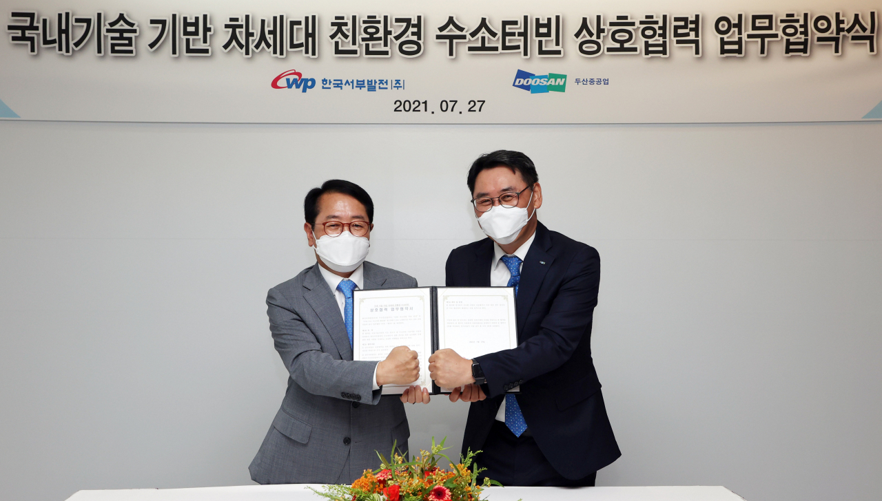 정영인 두산중공업 사장(오른쪽)이 박형덕 한국서부발전 사장과 경남 두산중공업 창원공장에서 '국내 기술 기반 차세대 친환경 수소터빈 상호협력 업무협약식'을 개최하고 기념촬영을 하고 있다.