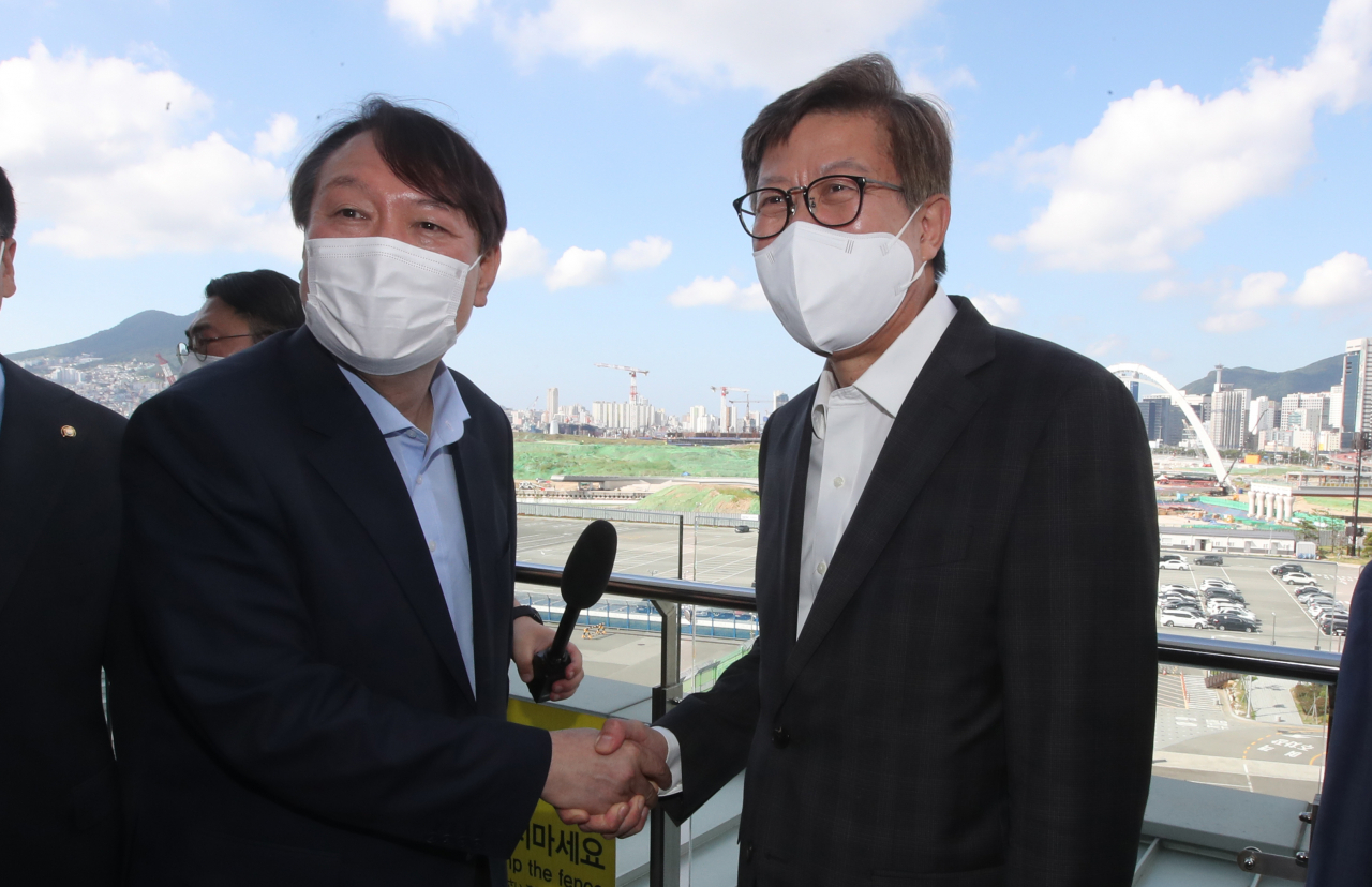 윤석열 전 검찰총장이 지난 27일 오전 부산 북항재개발 현장을 살펴보고 박형준 부산시장과 악수하고 있다. [연합]