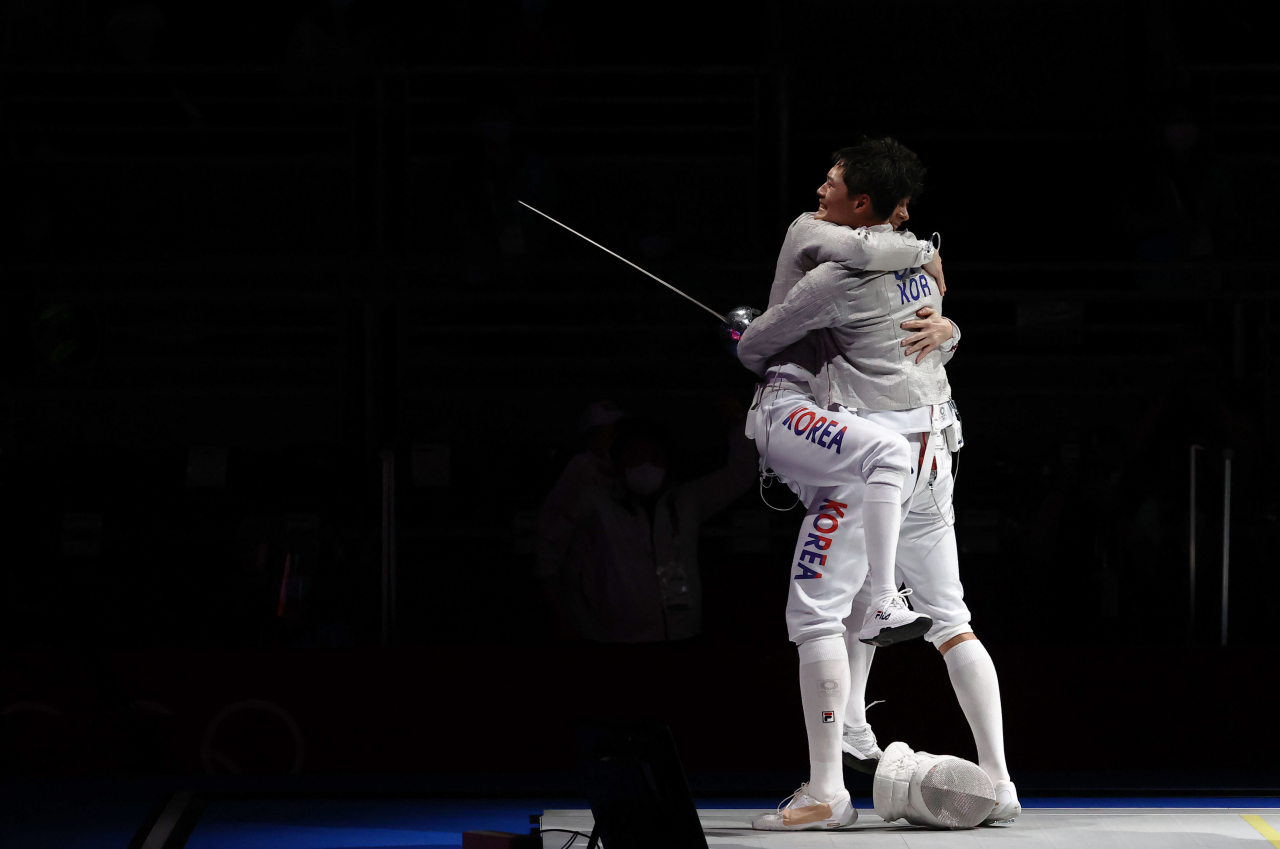 오상욱이 28일 일본 지바의 마쿠하리 메세에서 열린 도쿄올림픽 펜싱 남자 사브르 단체전 대한민국 대 독일 4강전에서 결승 진출을 확정지은 뒤 동료와 기뻐하고 있다. 연합뉴스