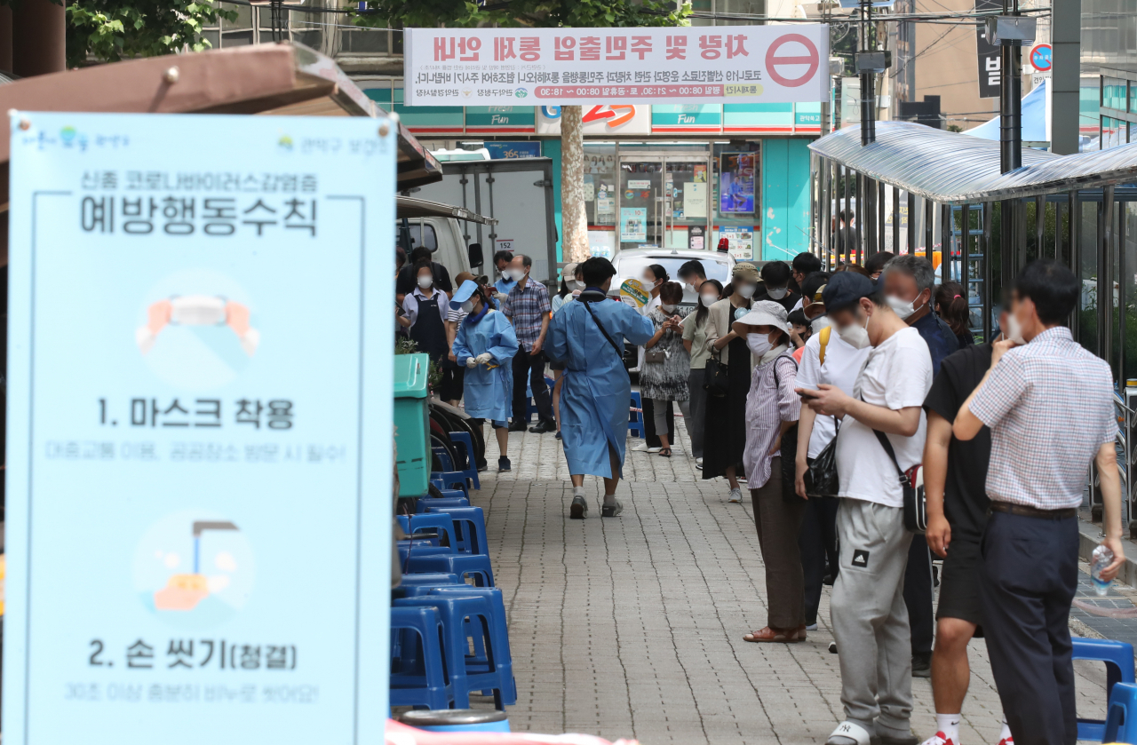 28일 서울 관악구 보건소 선별진료소에서 시민들이 코로나19 검사를 위해 길게 줄지어 서 있다. 연합뉴스