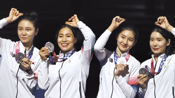 28일 남자 펜싱 사브르 단체전에서 우승한 한국 선수들이 시상대에서 금메달을 들어 보이고 있다. 왼쪽부터 구본길, 김정환, 김준호, 오상욱(위쪽 사진), 27일 여자 에페 단체전에서 준우승한 최인정, 강영미, 이혜인, 송세라(이상 왼쪽부터)가 은메달과 월계관 모양 반지를 들어 보이며 미소짓고 있다. [연합]