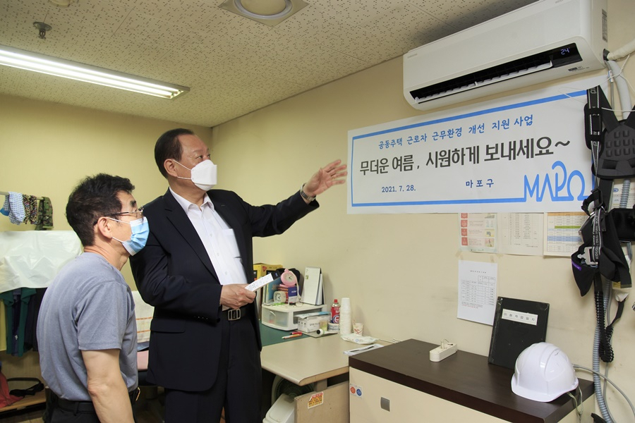 유동균 마포구청장(좌)이 마포트라팰리스2차아파트 경비원에게 에어컨 작동방법을 설명하는 모습. [마포구 제공]