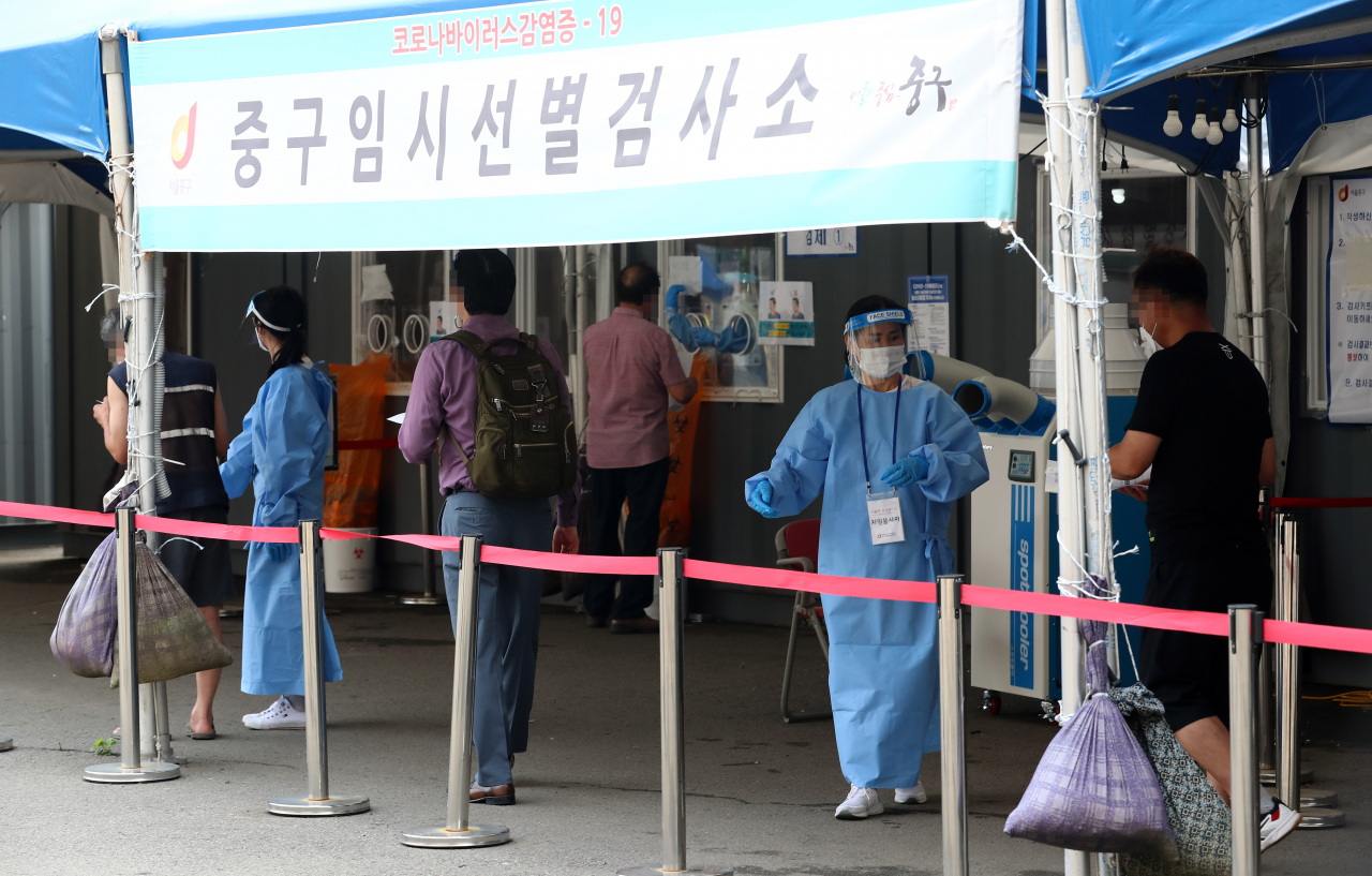 29일 오전 서울시 중구 봉래동 서울역 광장에 마련된 코로나19 임시선별진료소를 찾은 시민들이 검사를 위해 대기하고 있다. 연합뉴스