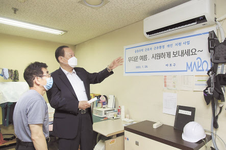 유동균(오른쪽) 마포구청장이 아파트 경비원에게 에어컨 작동법을 설명하고 있다.