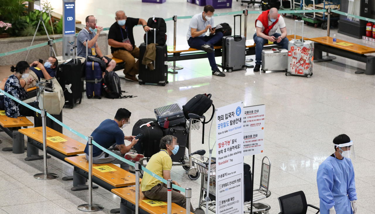 26일 오후 인천공항 입국장에서 독일 프랑크푸르트에서 입국한 외국인 입국자들이 격리 시설로 이동하기 전 대기하고 있다. 신종 코로나바이러스 감염증 델타형 변이로 인한 감염자가 전 세계적으로 급증하고 있는 가운데, 해외 입국자 방역에도 비상이 걸렸다. 이날 정부는 정례브리핑에서 코로나19 델타형 변이 국내 감염률이 금주에 50% 넘을 것으로 예상해, 사실상 국내에서도 우세 종으로 자리 잡을 것으로 보인다.[연합]
