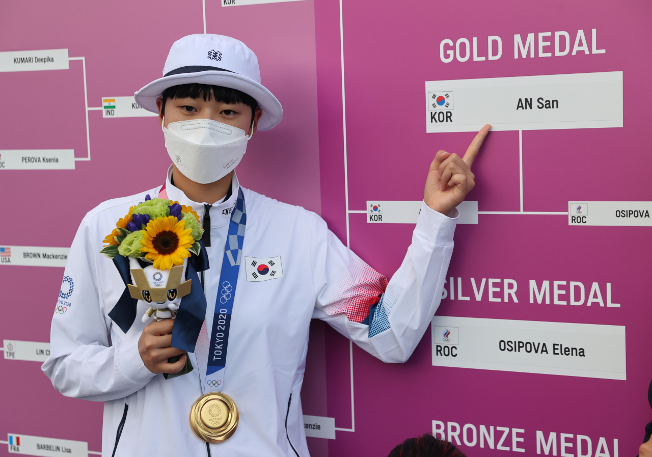 안산이 30일 일본 유메노시마 공원 양궁장에서 열린 도쿄올림픽 양궁 여자 개인전 시상식에서 금메달을 목에 걸고 자신의 이름을 가리키고 있다. 연합뉴스