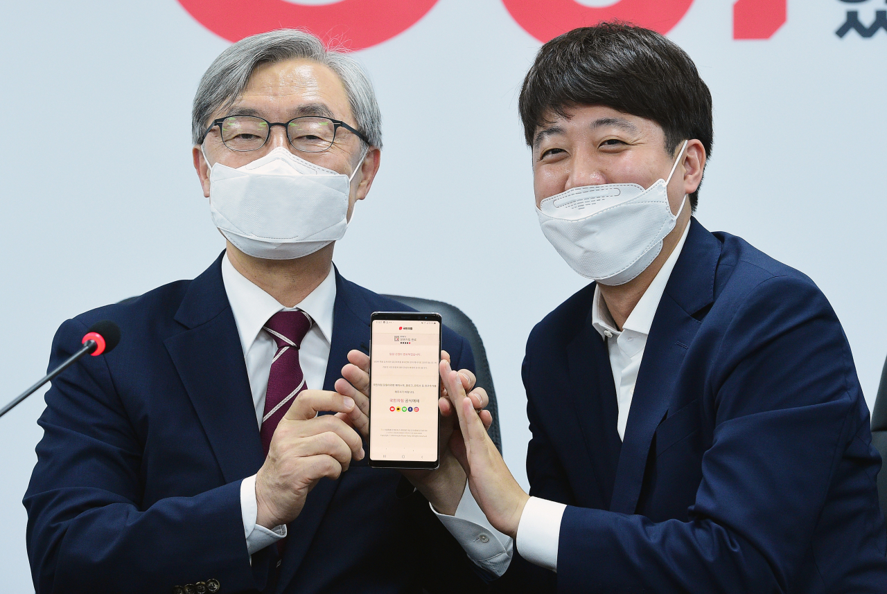 최재형 전 감사원장이 지난 15일 서울 여의도 국민의힘 당사에서 이준석 대표의 도움을 받아 모바일 입당원서를 작성한 뒤 들어보이고 있다. [이상섭 기자/babtong@heraldcorp.com]