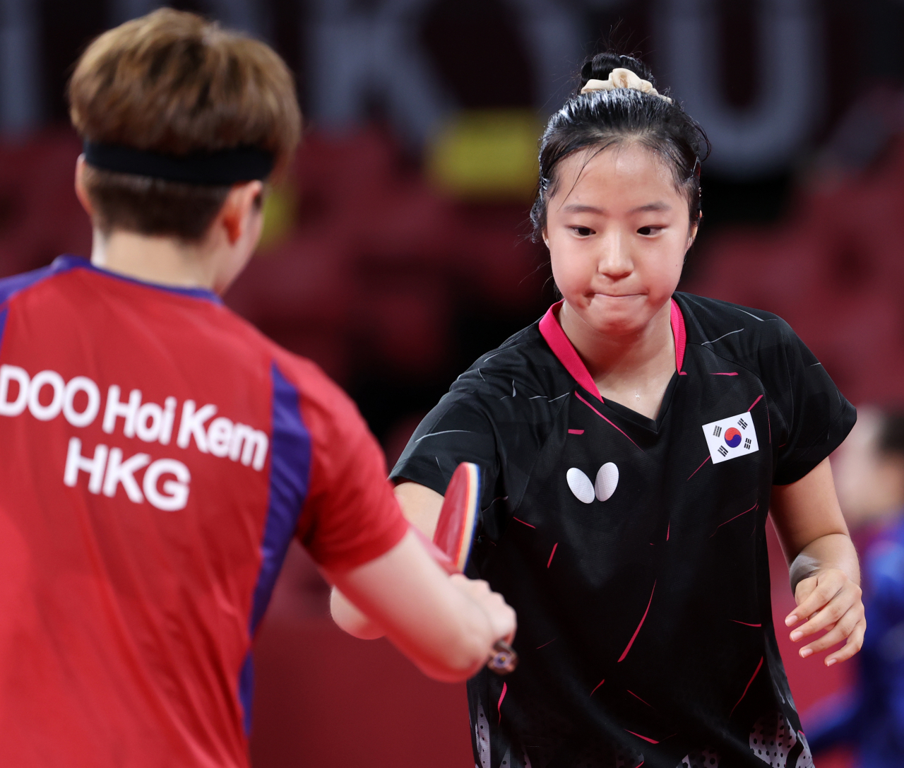 한국 탁구 국가대표 신유빈이 27일 도쿄체육관에서 열린 도쿄올림픽 여자탁구 개인전 홍콩 두 호이 켐과 경기에서 패배한 후 상대와 인사하고 있다. [연합]