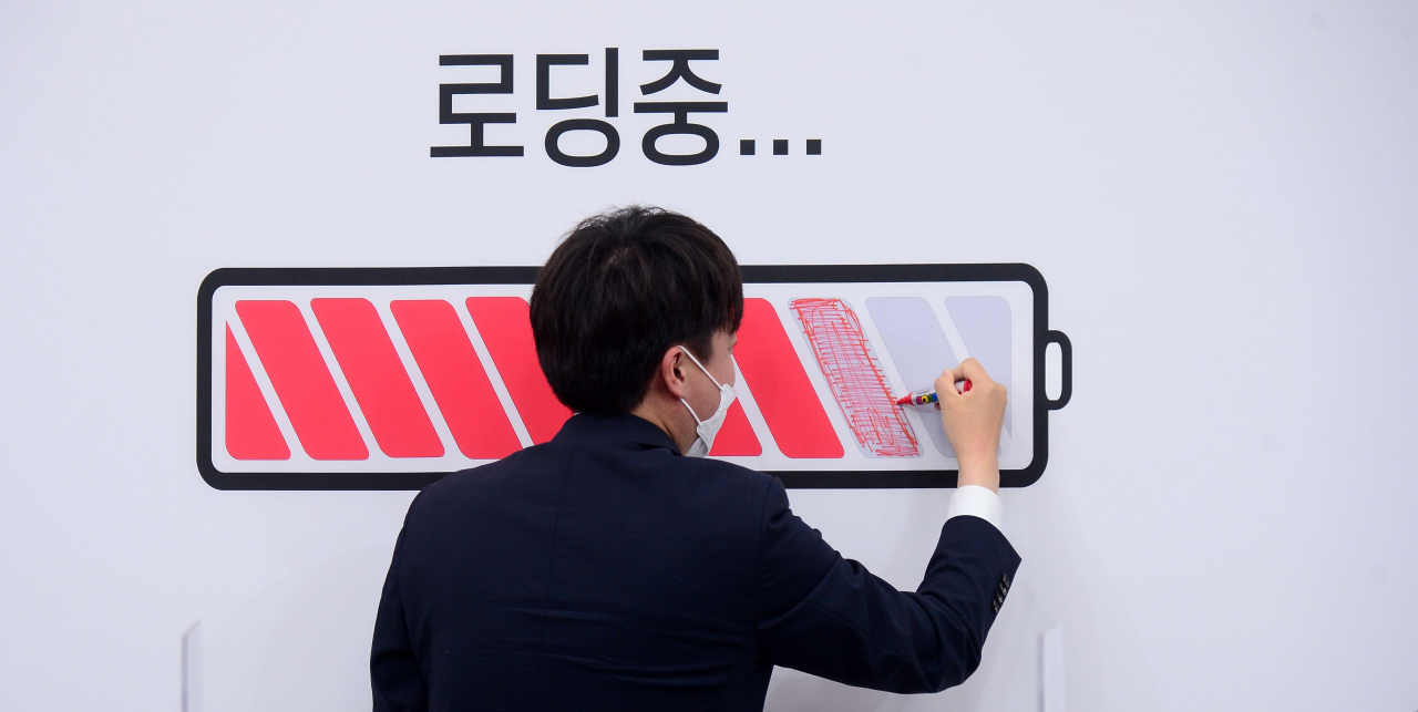 국민의힘 이준석 대표가 지난달 26일 오전 서울 여의도 국회에서 열린 최고위원회의에서 더 많은 대선 주자들과 함께 완전하 충전된 상태에서 대선 경선을 치를 수 있도록 한다는 의미의 배경판에 색칠하는 퍼포먼스를 하고 있다. 이 대표는 지난 25일 윤석열 전 검찰총장과 치맥 회동을 했다. 이상섭 기자/
