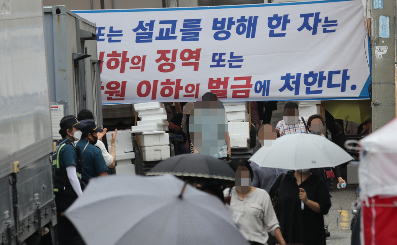 사랑제일교회가 1일 또 대면예배를 강행했다. 이날 오후 대면 예배를 마친 교인들이 교회를 나서고 있는 모습을 경찰과 구청 관계자들이 채증하고 있다. [연합]