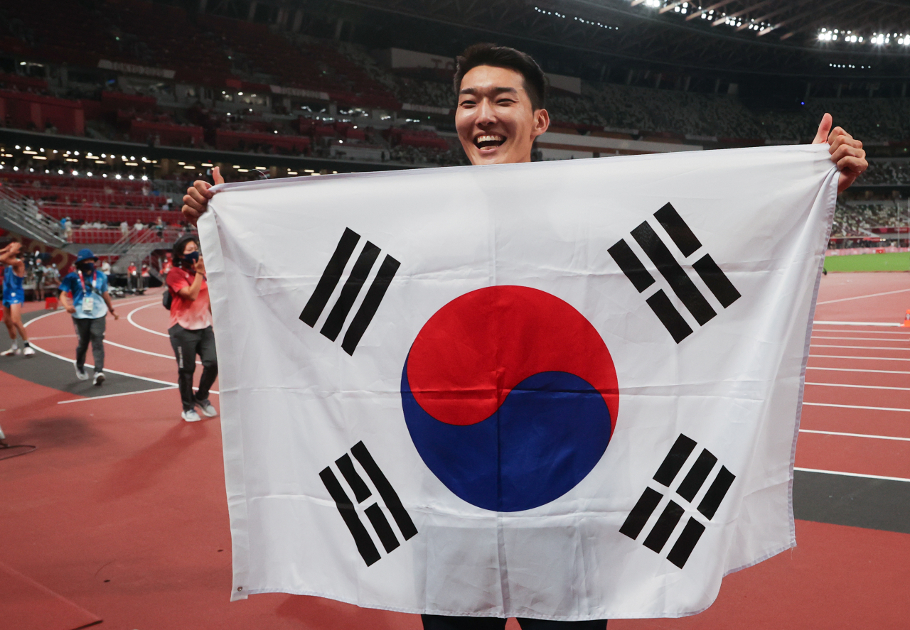 도쿄올림픽 남자 높이뛰기에서 2m35 한국신기록을 세우며 4위를 차지한 우상혁이 1일 도쿄 올림픽스타디움에서 태극기를 펼치며 기뻐하고 있다. 연합뉴스