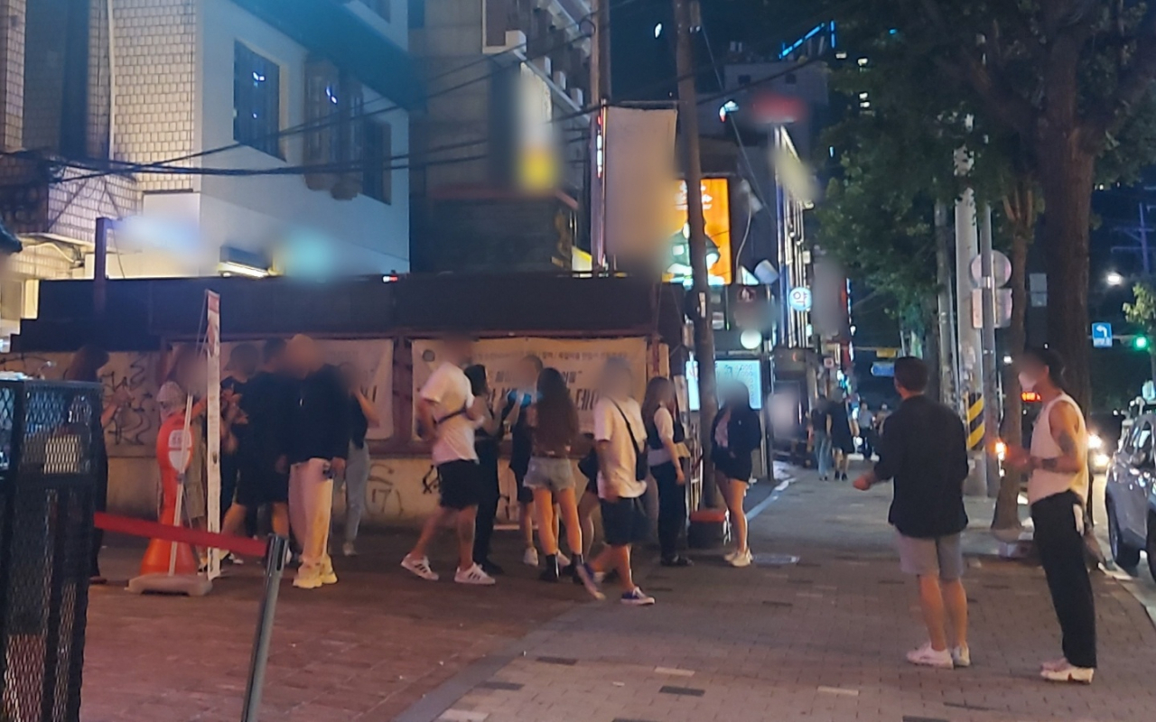 지난달 31일 밤 서울 마포구 홍대클럽거리의 한 주점 앞에서 사람들이 담배를 피우고 있다. 김희량 수습기자