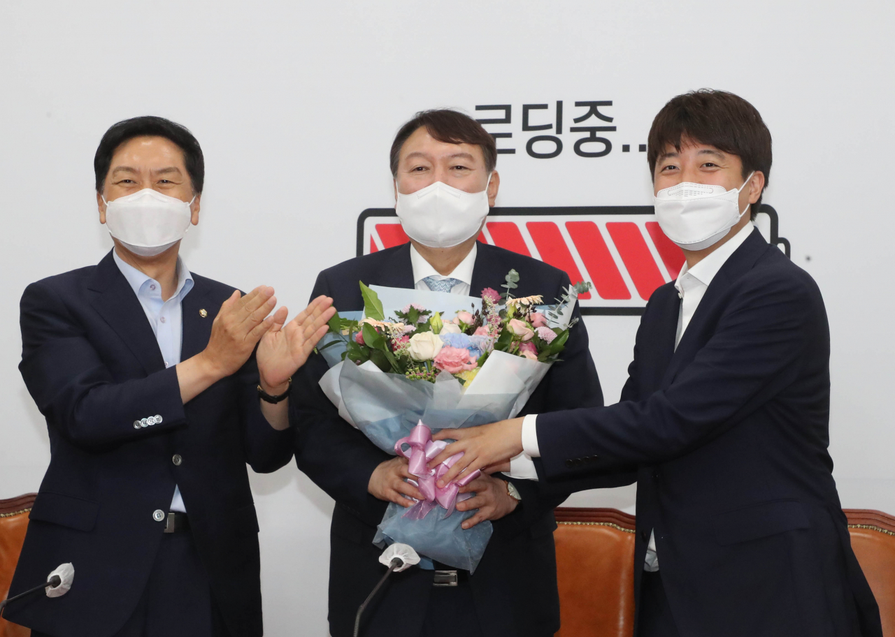 윤석열 대선 예비후보(가운데)가 2일 오전 서울 여의도 국회에서 국민의힘 이준석 대표(오른쪽)로부터 환영 꽃다발을 받고 있다. [헤럴드경제=이상섭 기자]