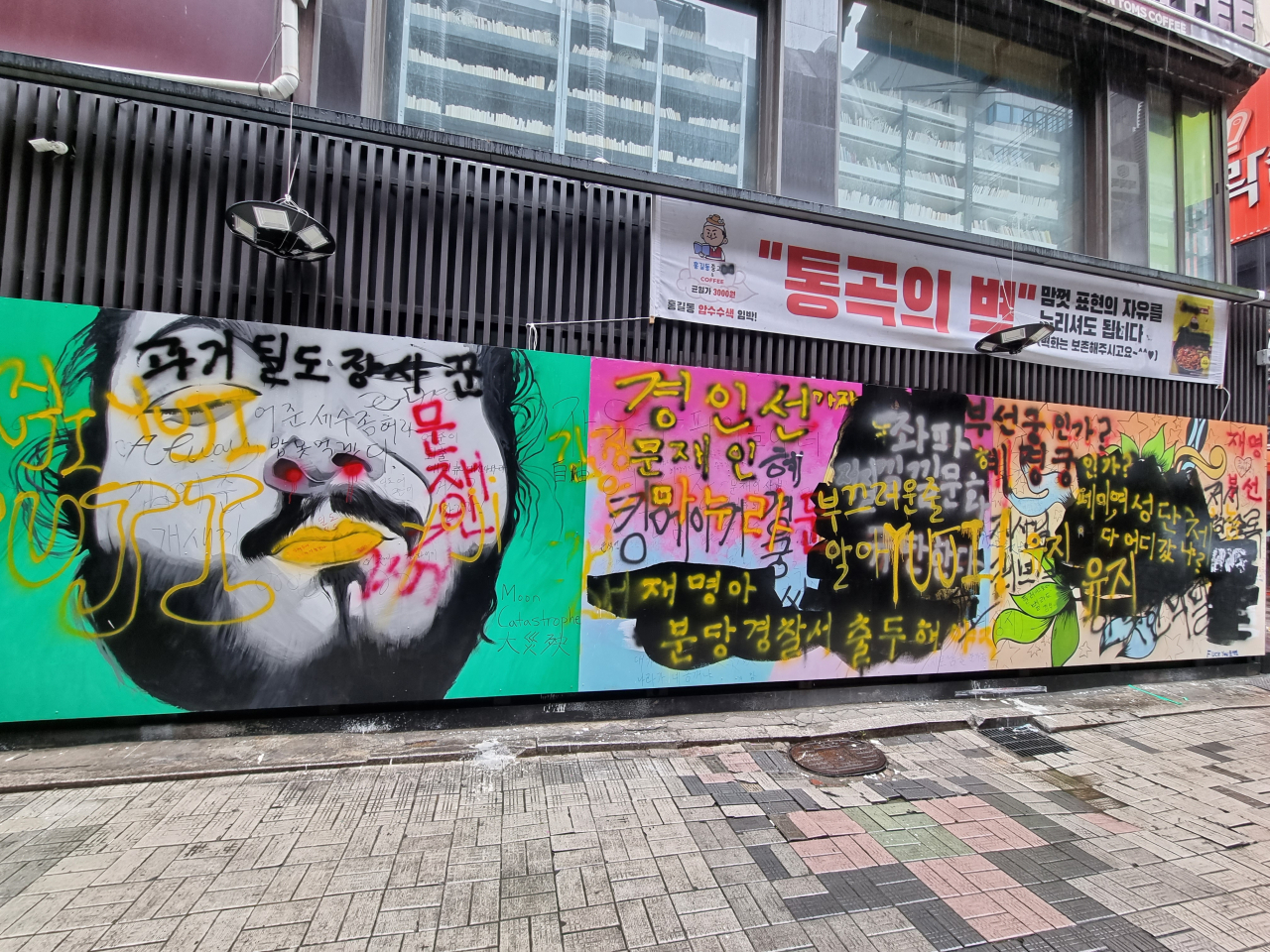 2일 서울 종로구의 한 중고 서점 측면 벽. 윤석열 전 검찰총장의 아내 김건희 씨를 비방하는 내용을 담은 ‘쥴리 벽화’에 검은색 페인트와 정부 등을 풍자하는 문구가 어지럽게 적혀 있다. 김영철 수습기자