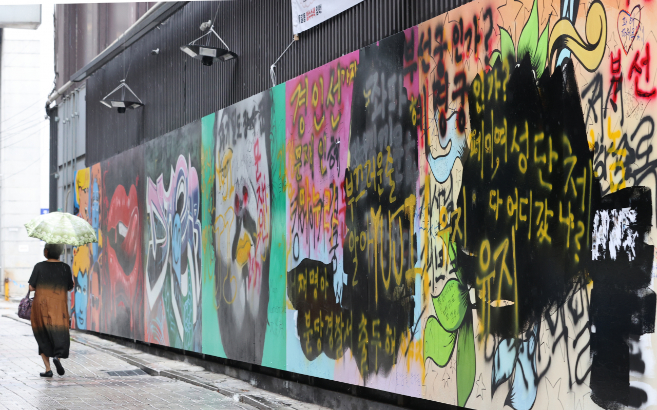 서울 종로구 관철동의 한 중고서점 앞에 윤석열 전 검찰총장 아내 김건희 씨를 비방하는 내용의 벽화가 게시돼 논란이 이어지는 가운데 한 유튜버가 벽화 위에 검은색 페인트로 덧칠했다. 사진은 1일 검은색 페인트로 덧칠된 벽화. [연합]