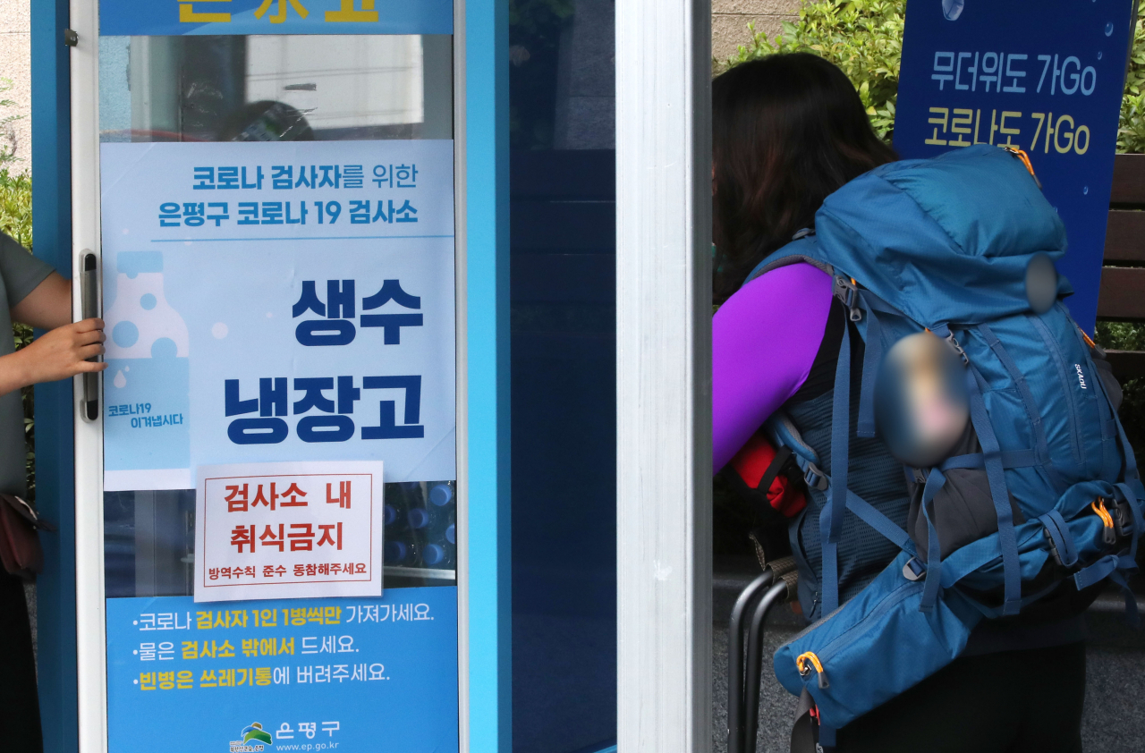 3일 오전 서울 은평구 구파발역 임시선별진료소을 찾은 시민들이 코로나19 검사 뒤 생수를 받고 있다. 중앙방역대책본부는 이날 0시 기준으로 신규 확진자가 1202명 늘어 누적 20만2203명이라고 밝혔다. 연합뉴스