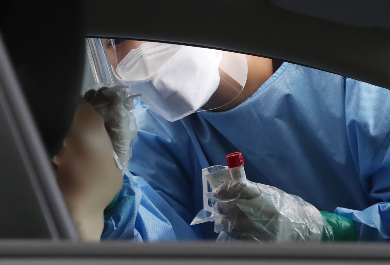 4일 오전 서울 중랑구 망우 저류조공원에 설치된 드라이브스루 임시선별검사소에서 의료진이 검체 채취를 하고 있다. 중앙방역대책본부는 이날 0시 기준으로 신규 확진자가 1천725명 늘어 누적 20만3천926명이라고 밝혔다. 연합뉴스