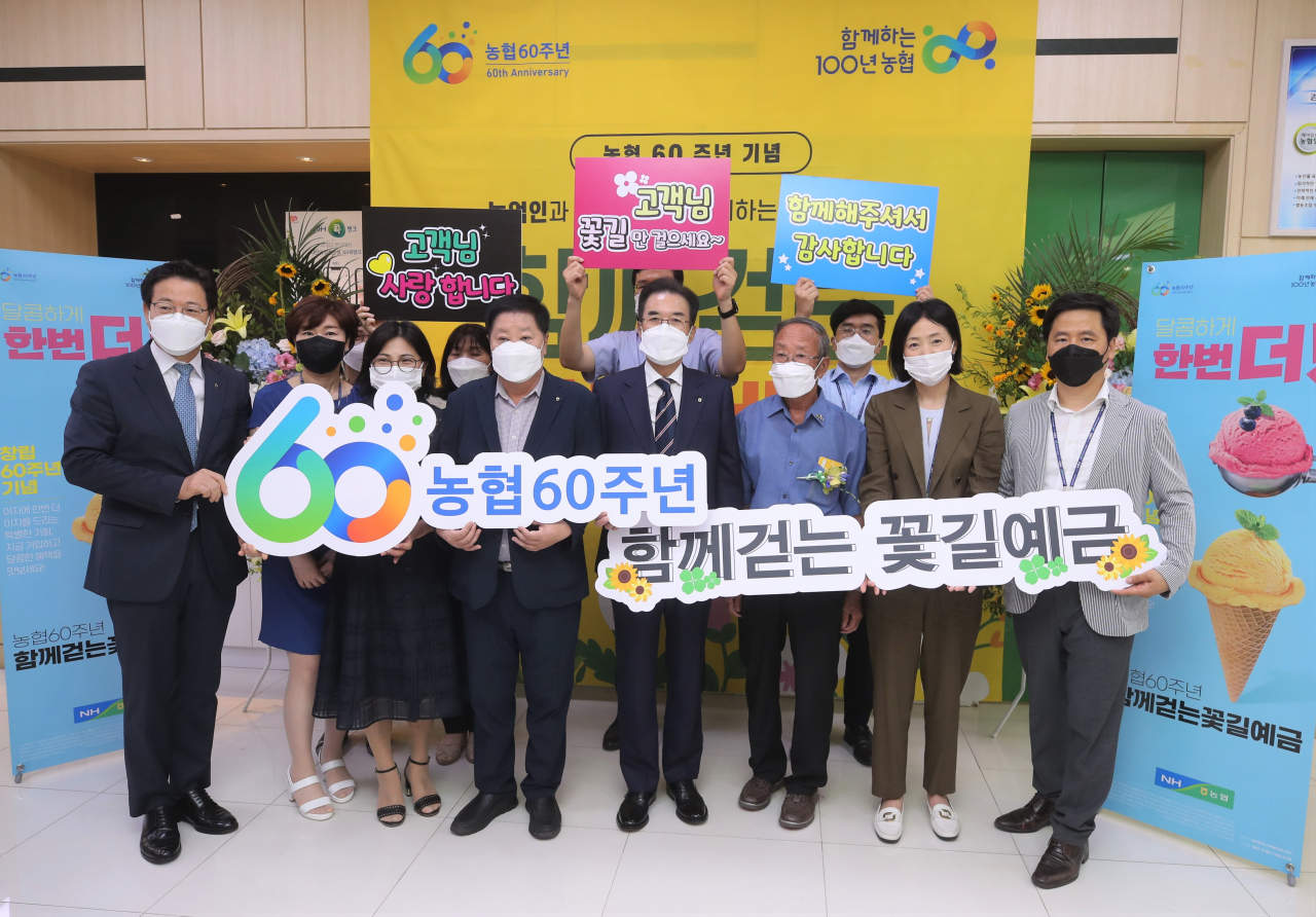 이성희 농협중앙회장(앞줄 오른쪽 네 번째)이 4일 강원도 강릉농협에서 열린 '함께 걷는 꽃길예금' 가입행사에서 이재식 농협상호금융대표이사(맨 왼쪽)를 비롯한 참석자들과 기념 촬영을 하고 있다. [농협 제공]