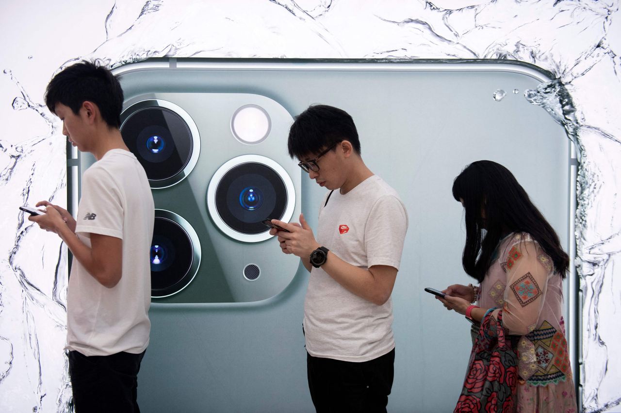 애플이 올 하반기 미국 아이폰 이용자들을 대상으로 아이폰 소프트웨어 IOS 15 업데이트에 나서면서 아동성범죄 관련 사진을 탐지할 수 있는 프로그램을 보급할 예정이다. 사진은 아이폰을 사용하는 청소년. [AFP]