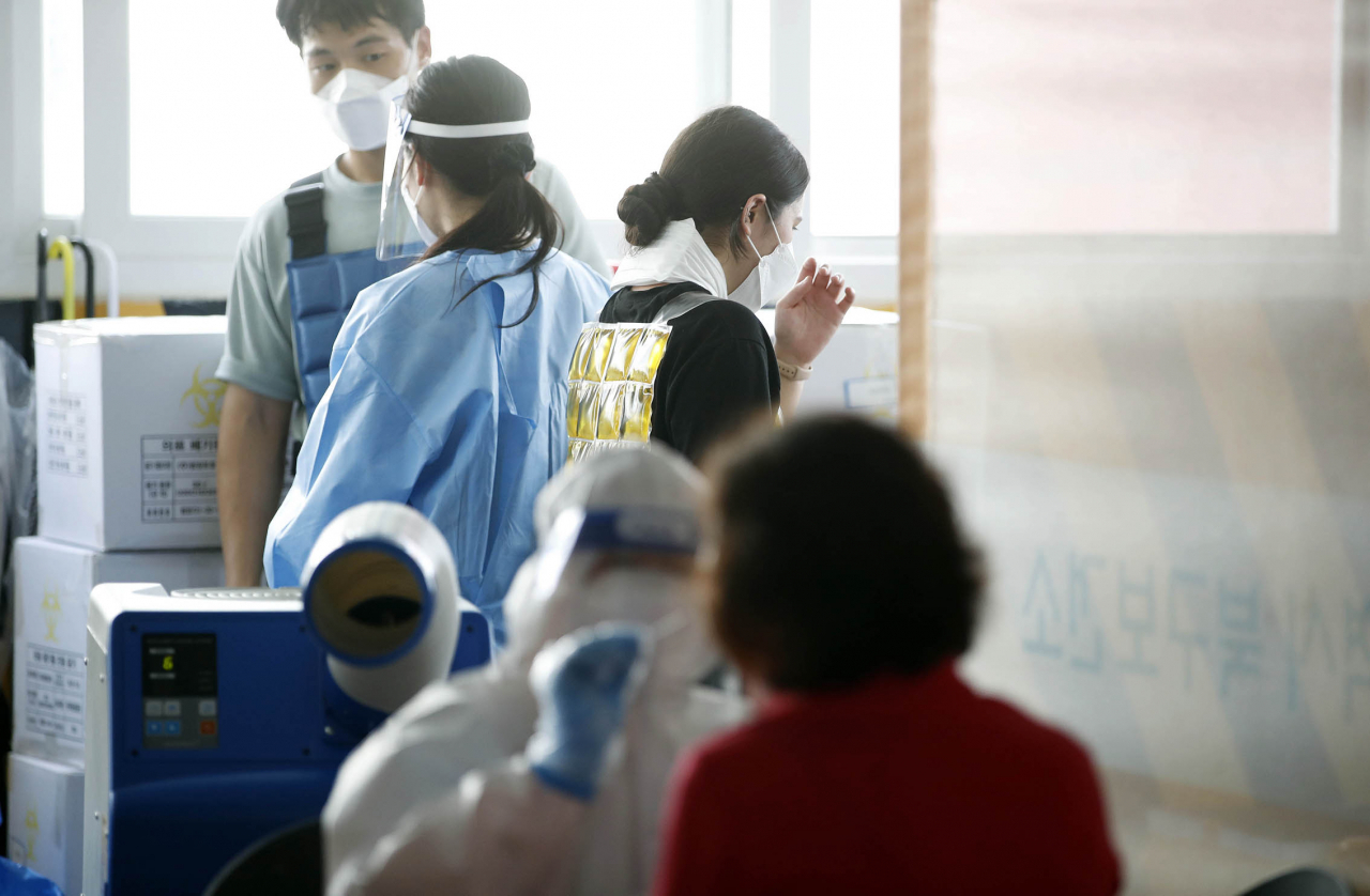 광주 북구 선별진료소에서 보건소 의료진들이 폭염 속에 냉조끼를 착용하고 일하고 있다. [연합]