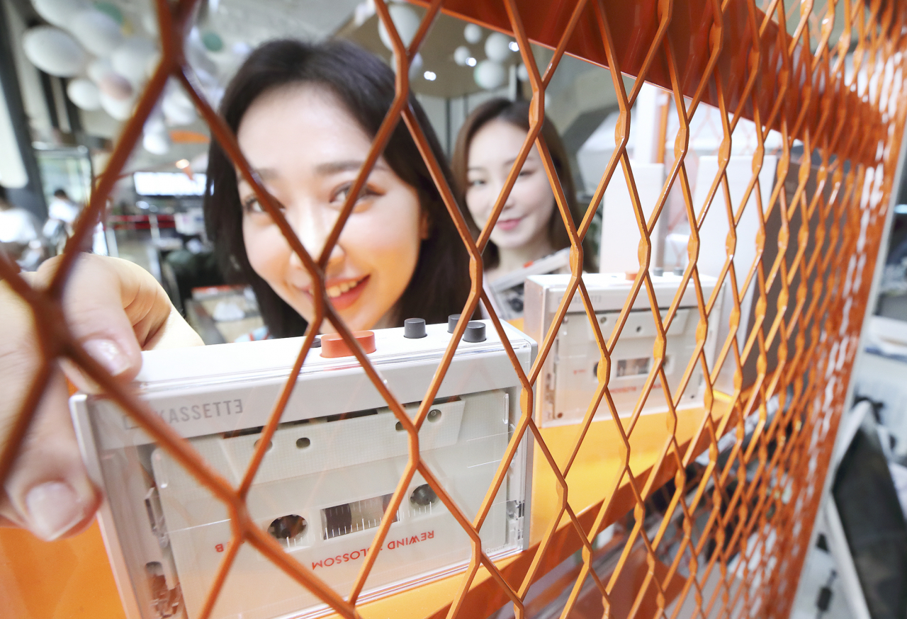 KT 모델들이 복고풍 카세트 플레이어 ‘카세트(KASSETTE)’를 소개하고 있다. [KT 제공]