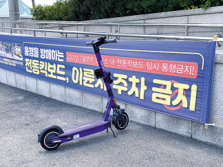 전동킥보드 통행·주차를 금지하는 현수막 바로 앞에 공유형 전동킥보드가 세워져 있다. [헤럴드경제DB]