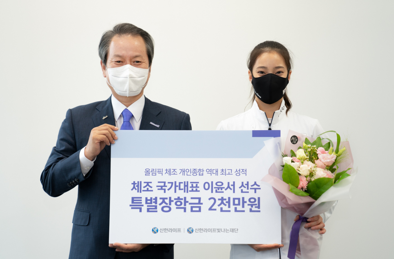 서울 중구 신한라이프빛나는재단 사무실에서 성대규(왼쪽) 신한라이프 이사장이 이윤서 선수에게 특별장학금을 전달한 후 기념 사진을 찍고 있다.