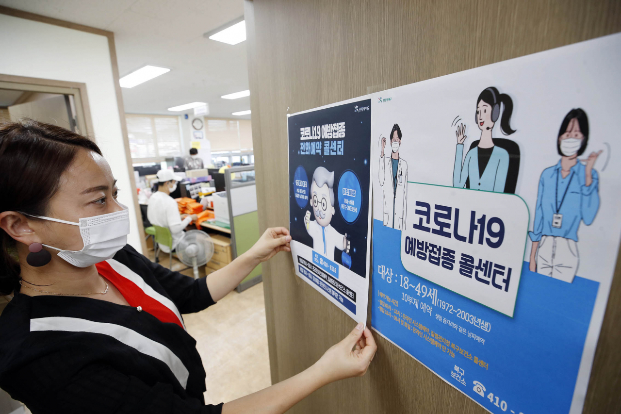 18~49세를 대상으로한 코로나19 백신 접종 사전 예약이 시작된 지난 9일 광주 북구보건서 콜센터에서 직원이 안내문을 붙이고 있다. [연합]