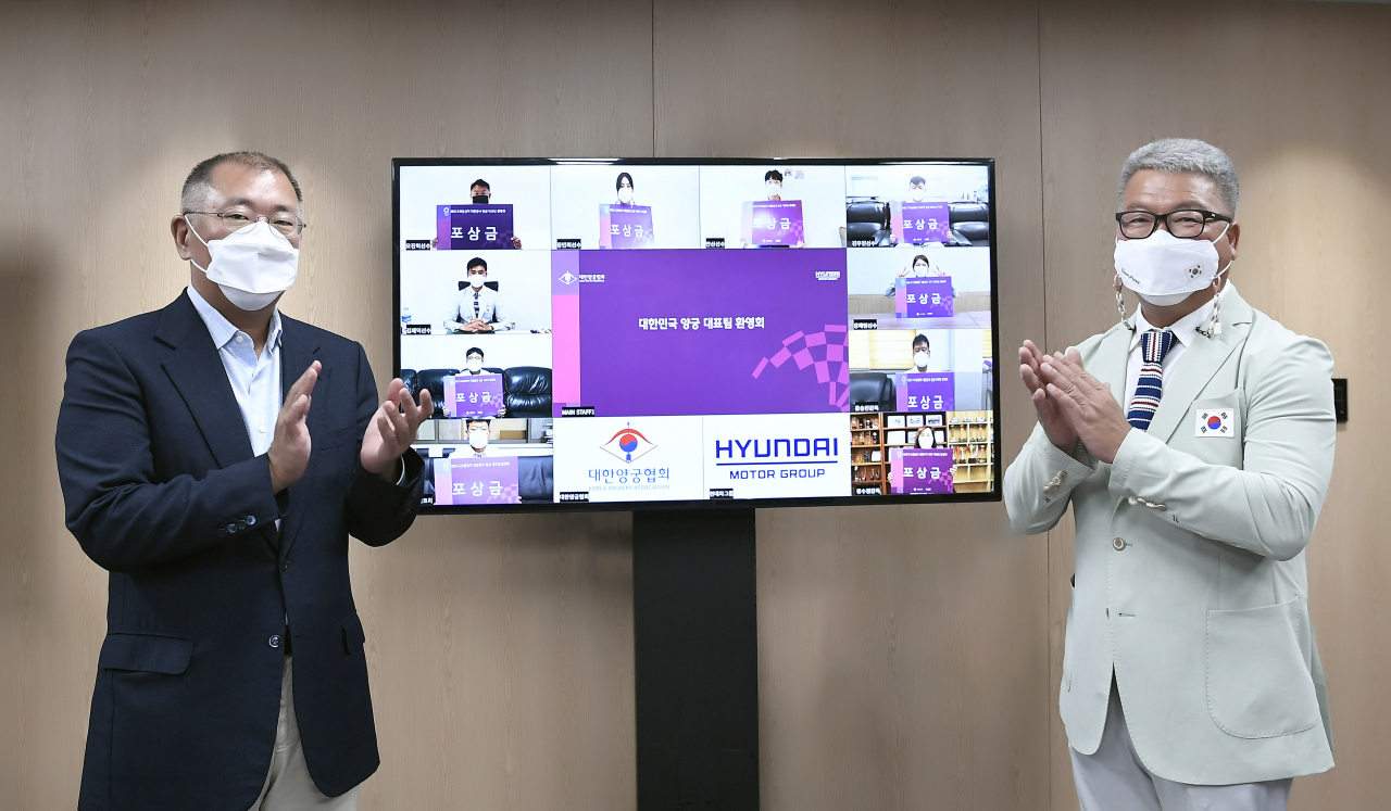 현대차그룹과 대한양궁협회는 10일 2020 도쿄대회에서 금메달 4개를 획득하며 세계 최강의 실력을 재확인한 국가대표 선수단을 축하하고 격려하는 대규모 ‘온택트’ 환영 행사를 개최했다. 박채순(오른쪽) 양궁 국가대표 총감독을 비롯해 국가대표 선수단이 정의선 양궁협회장(왼쪽·현대자동차그룹 회장)으로부터 포상금을 받고 기뻐하고 있다. [대한양궁협회 제공]