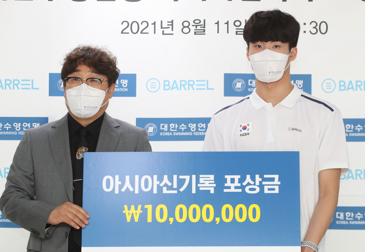 황선우가 11일 오전 서울 송파구 대한체육회 회의실에서 열린 대한수영연맹 아시아신기록 포상금 전달식에서 정창훈 연맹 회장(왼쪽)으로부터 포상금 1000만 원을 전달받고 있다. [연합]