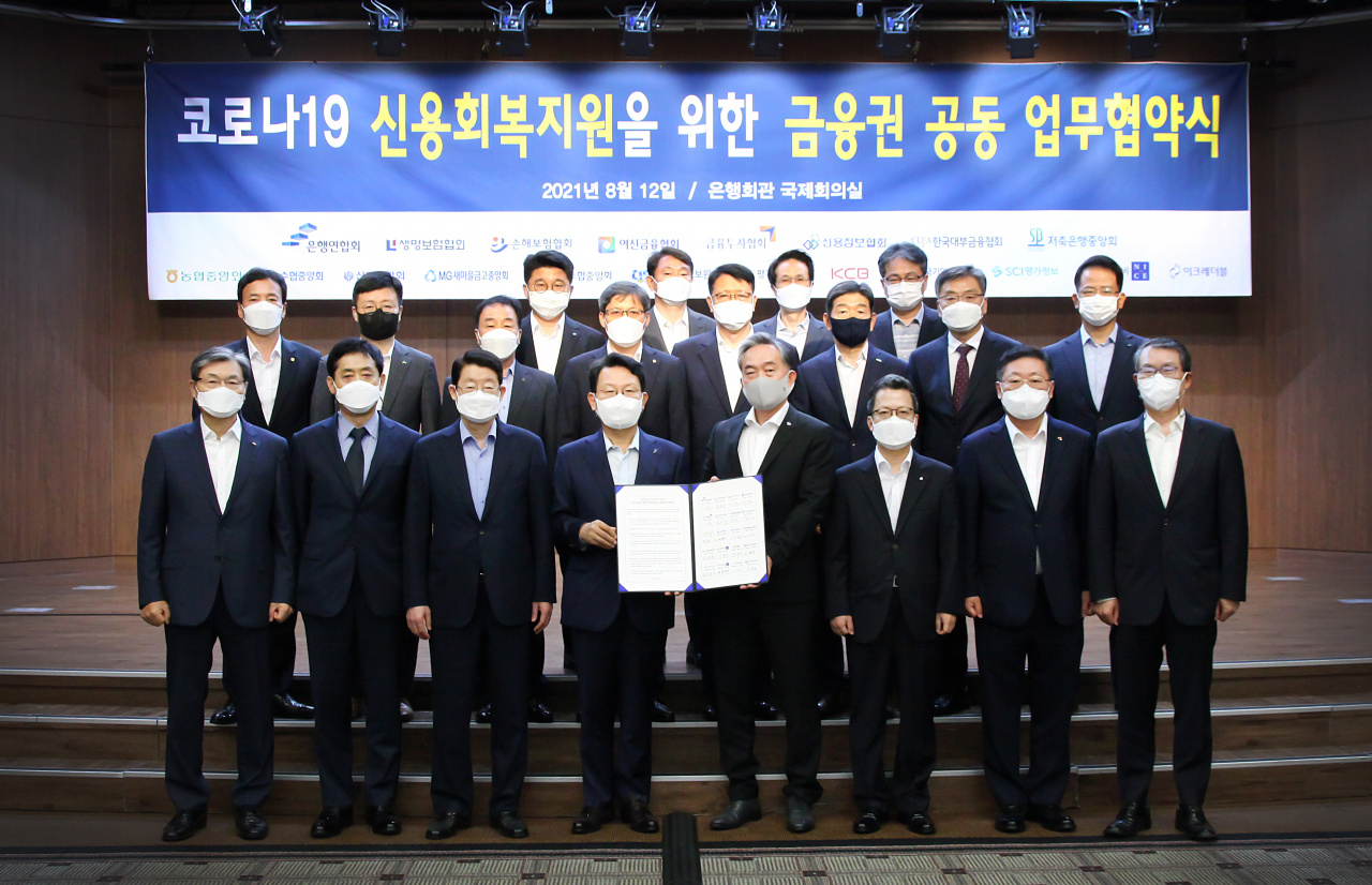 금융권 협회·중앙회, 신용정보원 및 6개 신용정보회사 대표들이 12일 서울 명동 소재 은행회관에서 '코로나19 신용회복지원을 위한 공동 업무 협약'을 체결한 뒤 기념 촬영을 하고 있다. 맨 앞줄 왼쪽부터 임승보 한국대부금융협회장, 김주현 여신금융협회장, 정희수 생명보험협회장, 김광수 은행연합회장, 신현준 한국신용정보원장, 정지원 손해보험협회장, 나재철 금융투자협회장, 김근수 신용정보협회장. [은행연합회 제공]