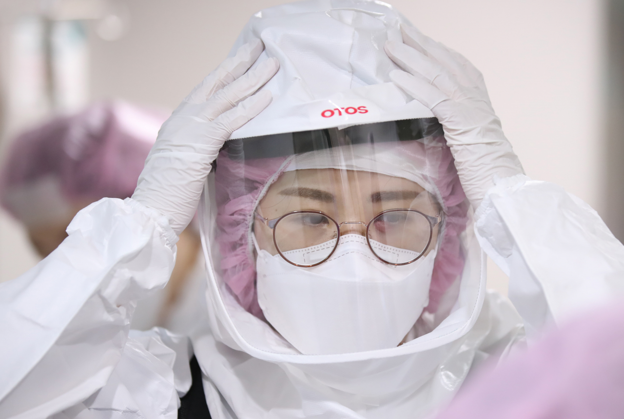 13일 오전 경기북부의 코로나19 거점 전담병원인 경기도 고양시 국민건강보험 일산병원에서 간호사들이 코로나19 확진 환자 제왕절개 수술을 위해 레벨D 방호복을 착용하고 있다.[연합]