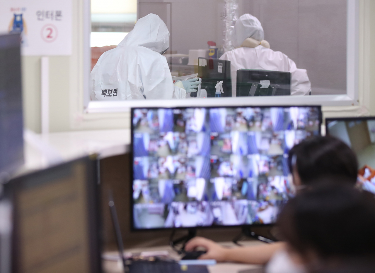 13일 오전 경기북부의 코로나19 거점 전담병원인 경기도 고양시 국민건강보험 일산병원 코로나 전담 병동에서 의료관계자가 환자 모니터링을 하고 있다. [연합]