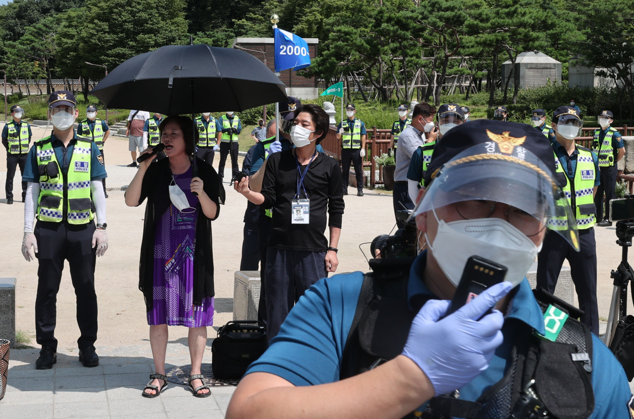 15일 오전 서울 종로구 종묘공원 앞에서 나라지킴이 고교연합 관계자가 정부의 방역 조치를 규탄하며 기자회견을 하고 있다. [연합]