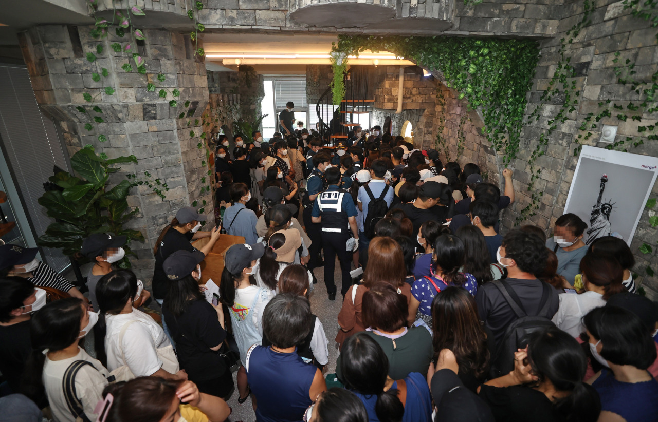 People line up in front of the headquarters of Mergeplus to demand a refund from the company in Seoul on Aug. 13, 2021. (Yonhap)