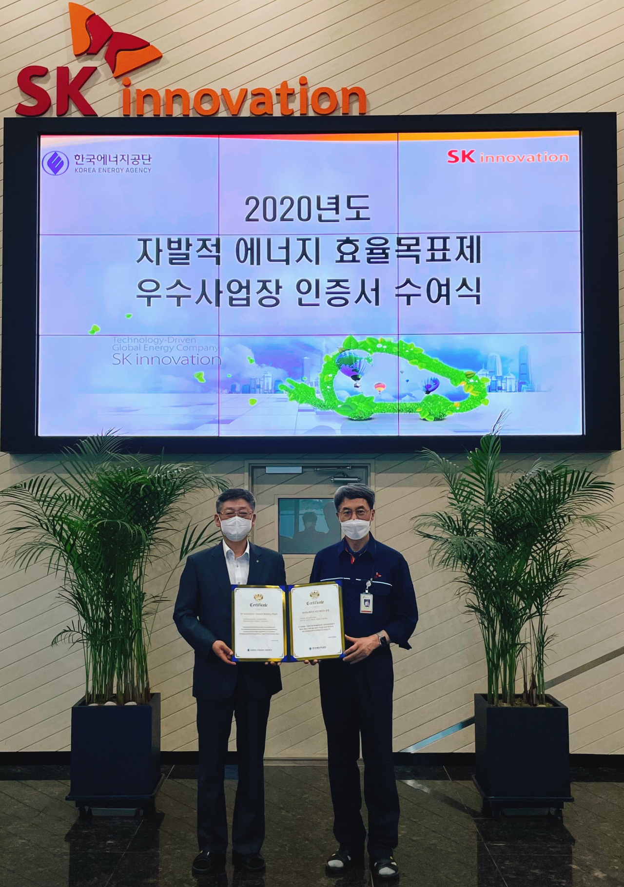 지난 12일 SK이노베이션 충남 서산 배터리 공장에서 박병춘 한국에너지공단 수요관리이사(왼쪽)가 김진영 SK이노베이션 생산기술본부장에게 ‘2020년 에너지효율목표제 우수사업장’ 인증서를 전달하고 있다.[SK이노베이션 제공]