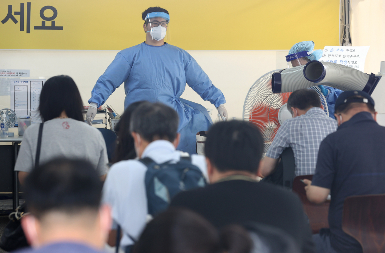 신종 코로나바이러스 감염증(코로나19) 신규 확진자 수가 1373명을 기록한 17일 서울 강남구보건소 선별진료소에서 의료진이 업무 중 냉풍기 앞에서 열기를 잠시 식히고 있다. [연합]